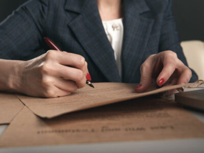 Closeup view of woman attorney writing on documents by pen